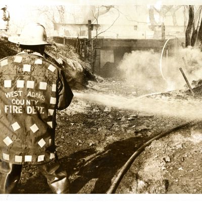 "Bridge Burned" West Adams Fire Dept. - man spraying hose at bridge