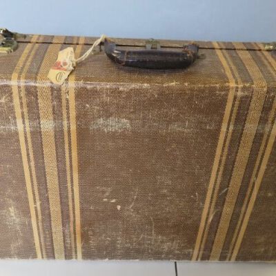 Side of suitcase showing tag: Origsize: 14" (h) x 21" (l) x; Origformat: Artifact