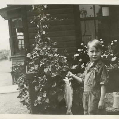 Robert Hillen with Caught Fish Standing by Clematis Plants