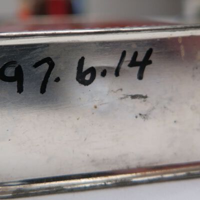 Bottom of tin: Origsize: 3" (h) x 2.25" (w) x; Origformat: Artifact