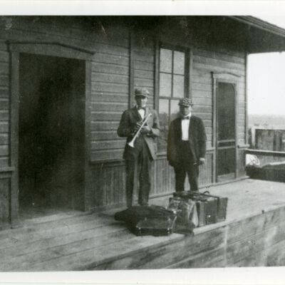 Two young men with a trumpet waiting at Broomfield depot, 1914: Origsize: 5" x 7"; Origformat: Print-Photographic; Resolution: 720dpi