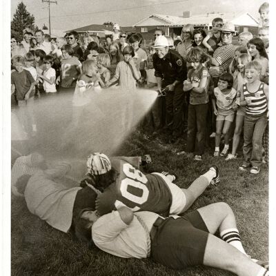 Fireman hosing tug-of-war participants - Broomfield Days?