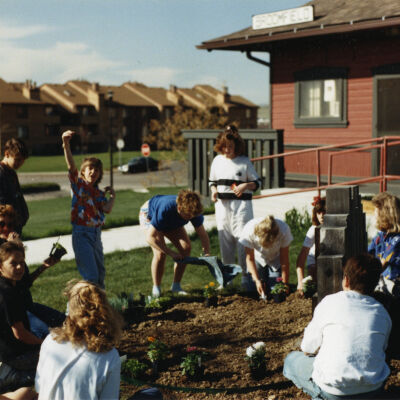 Kids Planting Near the Broomfield Historical Depot Sign and Museum