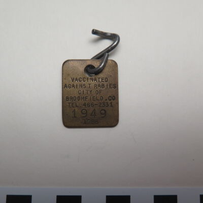 Close up of text on front of tag.: Origsize: 0.5" (w) x 1" (l); Origformat: Artifact