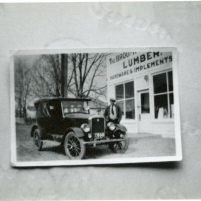 Ph.21a, Man standing by a car outside Broomfield Lumber Company, undated: Origsize: 3.5" x 5"; Origformat: Print-Photographic; Resolution: 1000dpi