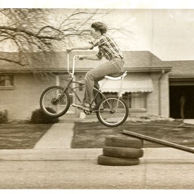 Young person jumping bike off a ramp