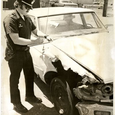 Policeman writing a ticket. 05/12/1976