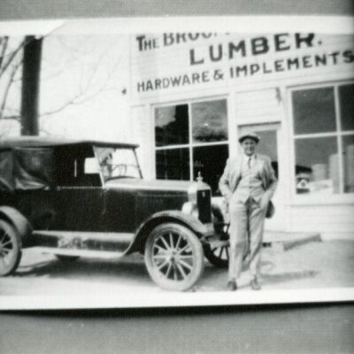 Man Standing by a Car Outside at Broomfield Lumber Company, undated: Origsize: 3.5" x 5"; Origformat: Print-Photographic; Resolution: 1000dpi