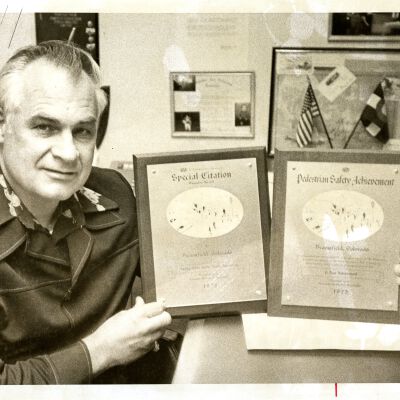 Man holding two plaques: "Special Citation" and "Pedestrian Safety Achievement"
