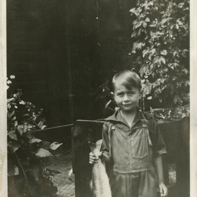 Robert Hillen with Caught Fish Standing by Clematis Plants