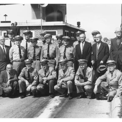 A Group Photo of Fifteen Tollbooth Workers and Men in Suits