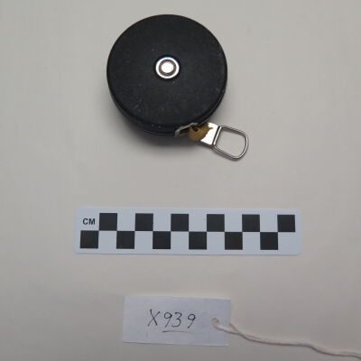 Bottom of measure tape.: Origsize: 1" (h) x 2.5" (dia); Origformat: Artifact