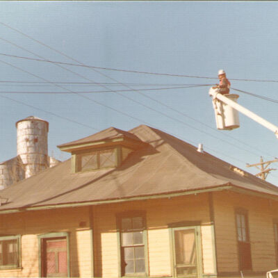 Man Holding Telephone Wires Above Broomfield Depot on Moving Day
