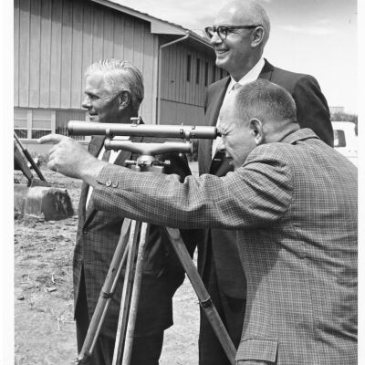 Three Men Using a Sextant at Construction Site