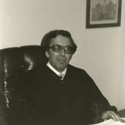 Man in Judge's Robe Sitting at Desk