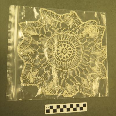 One side of doily in bag.: Origsize: 10" (w) x 11" (l); Origformat: Artifact