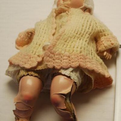 Front of doll showing damage to legs: Origformat: Artifact