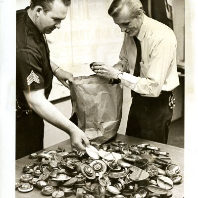Two Policemen and a table covered with gas caps