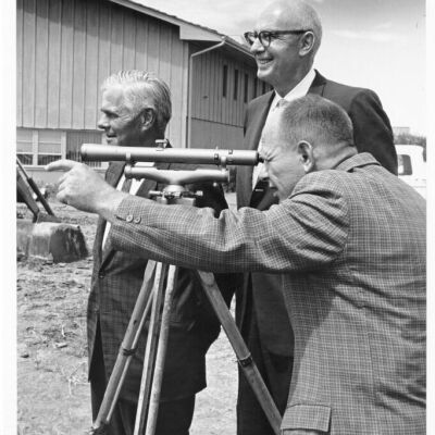 Three Men Using a Sextant at Construction Site