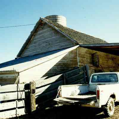 Silo on Brunner Property with a Building and a White Truck