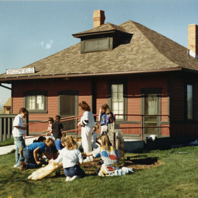 Kids Planting Near the Broomfield Historical Depot Sign and Museum