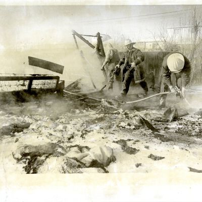 "Broomfield Building" - Firemen, one with hose - aftermath of fire