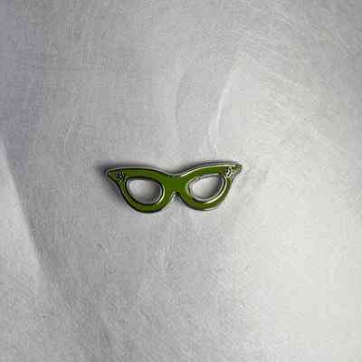 2 pins: Green cat eye glasses. Lady of the Grand Master pins, Lynn Coffman (2020-2021).