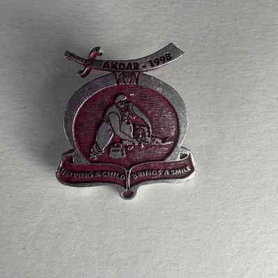 Pin: Shriner. Akdar. "Helping a Child Brings a Smile". Donated by PGM James O. Wood (1998)