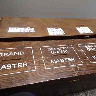 2 Voting Boxes: Large, long wooden boxes with slots. Locked