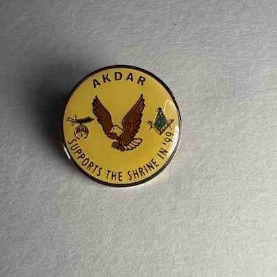 Pin: Circular. Shriner. "Akdar/Supports the Shrine in '99". Donated by PGM James O. Wood (1999)