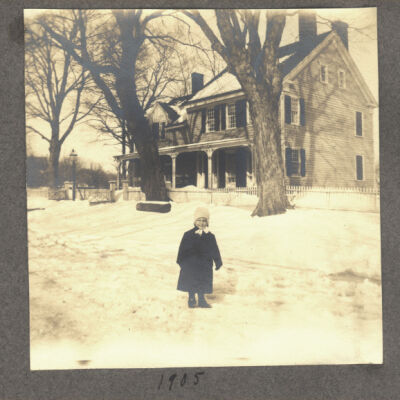 unidentified child in front of house in snow