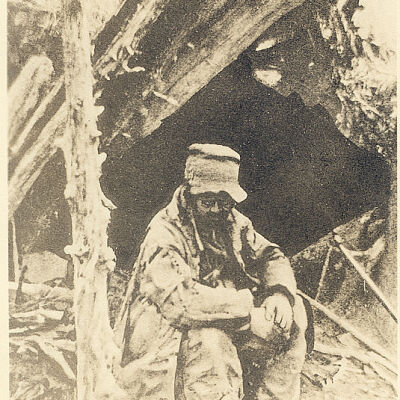 The Leather Man sitting by his cave.