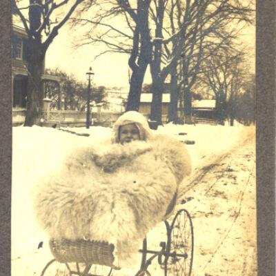 unidentified child in carriage on snowy road