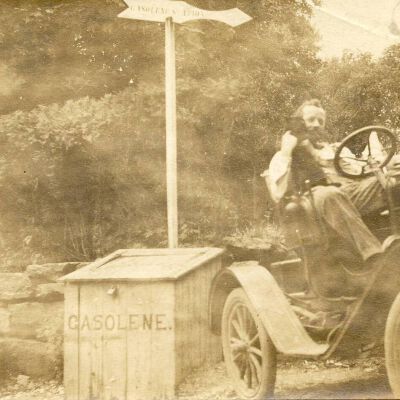 Unidentified man next to Gasolene Station sign