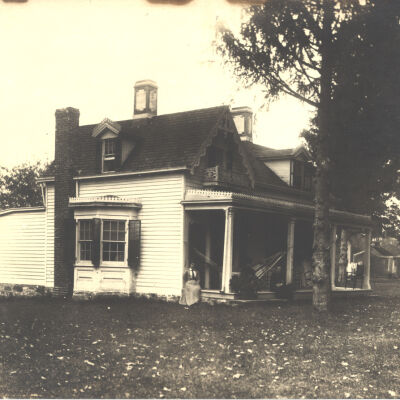 Cottage belonging to Wood House, 1894, with two women sitting on front porch