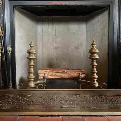 Andirons on display with fire tools and fire fender.