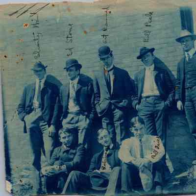 Group of men posing in front of brick wall