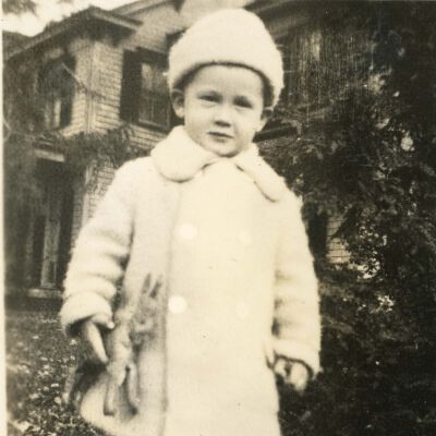 Claude Potts, Jr. in winter wear holding stuffed horse