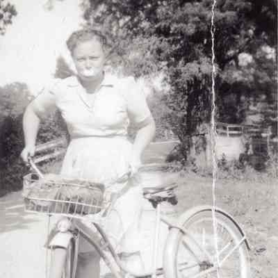 M. Doty on her bike, blowing bubble gum.