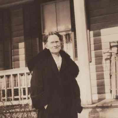 Woman (Fraleigh?) standing in front of house