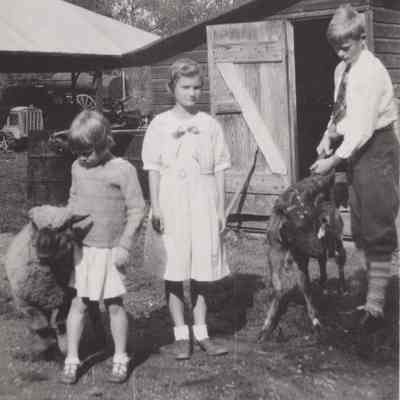 Three children with animals on the Mead farm