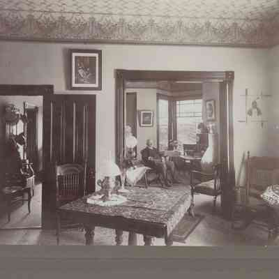 W.P. Adams seated in his house