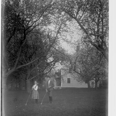 Roscoe and Marion Teator on lawn with golf clubs (?)