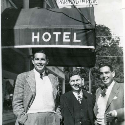 Three men in front of Red Hook Hotel