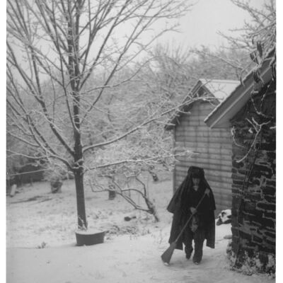 Unidentified person with broom in snow