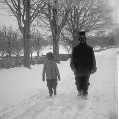 Man and child walking in snowy lane