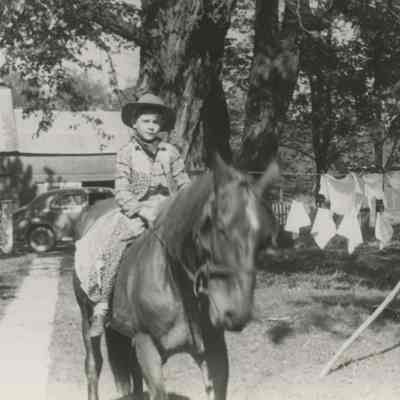 Kevin Klose on horseback in farmyard, c. 1947