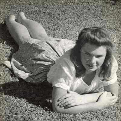 Beth Mead as a young woman, lying on grass