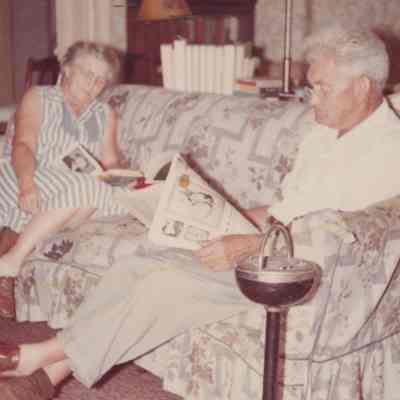 G. Gordon and Fay Mead sitting on a couch reading, 1960