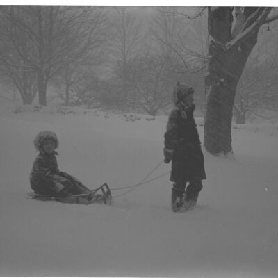 Roscoe Teator pulling Marion Teator on a sled